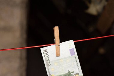 A 100 Euro bill on a clothesline with clothespin clipart