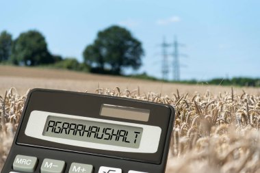 Arable field, calculator and agricultural budget clipart