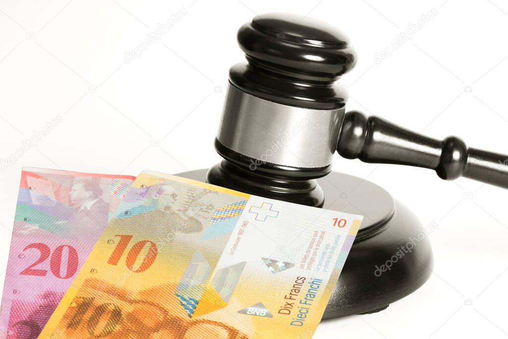 Judge's gavel and Swiss franc banknotes