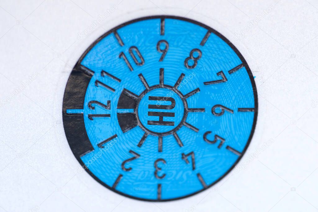 A blue technical inspection association badge and a magnifying glass