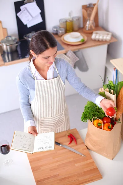 Mujer haciendo comida saludable de pie sonriendo en la cocina — Foto de Stock