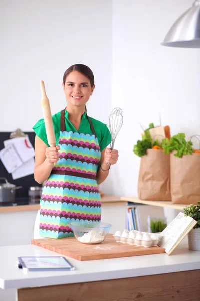 制作健康食品站在厨房里微笑的女人 — 图库照片