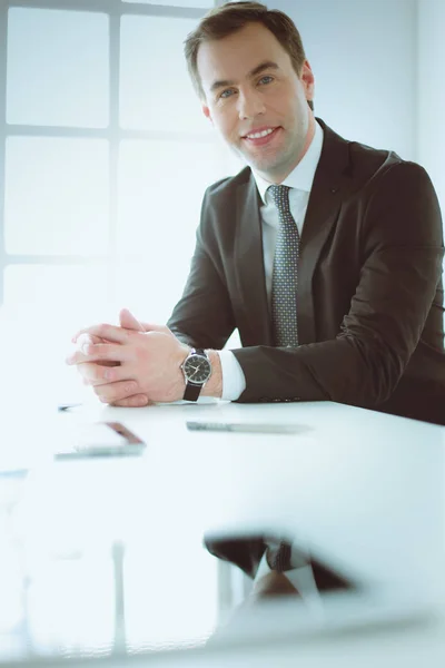 Porträt eines jungen Mannes, der an seinem Schreibtisch im Büro sitzt — Stockfoto