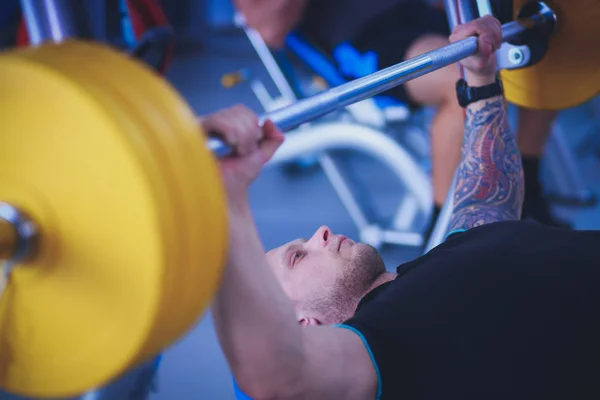 Bodybuilder med skivstång i gymmet. Bodybuilder — Stockfoto