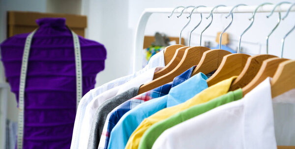 Одежда висит на полке в дизайнерском магазине
