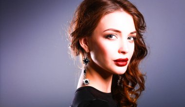 Siyah elbiseli, akşam makyajlı güzel bir kadın.