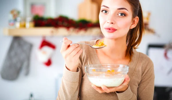 Jeune femme qui sent debout dans sa cuisine — Photo