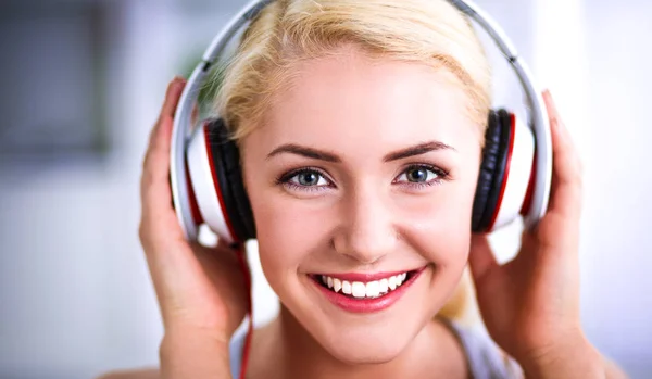 Young beautiful woman at home sitting on sofa and listening music — Stock Photo, Image