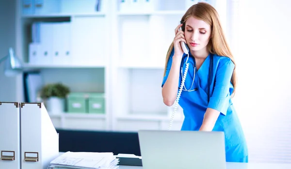 Female doctor talking on phone in diagnostic center — Stock Photo, Image