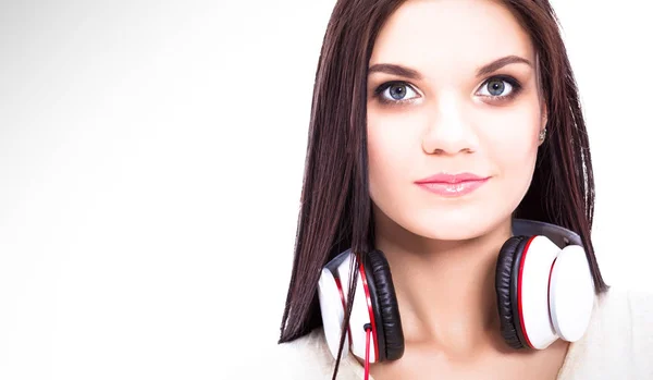 Smiling girl with headphones sitting on the floor near wall — Stock Photo, Image