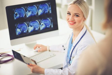 Doktor ve hasta masada otururken bir şey tartışıyorlar. Tıp ve sağlık hizmetleri kavramı. Doktor ve hasta.