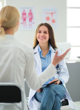 Doktor ve hasta masada otururken bir şey tartışıyorlar. İlaç ve sağlık hizmetleri kavramı