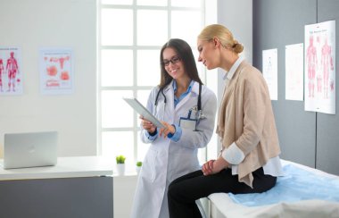 Doktor ve hasta masada otururken bir şey tartışıyorlar. İlaç ve sağlık hizmetleri kavramı.