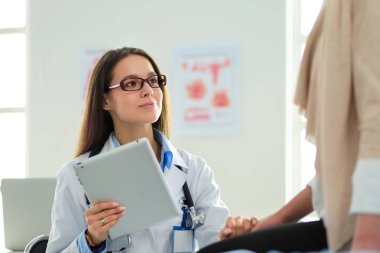 Doktor ve hasta masada otururken bir şey tartışıyorlar. İlaç ve sağlık hizmetleri kavramı