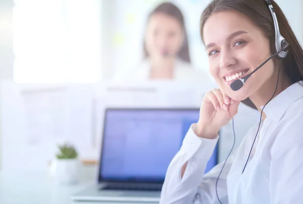 Mujer de negocios sonriente u operador de línea de ayuda con auriculares y computadora en la oficina — Foto de Stock