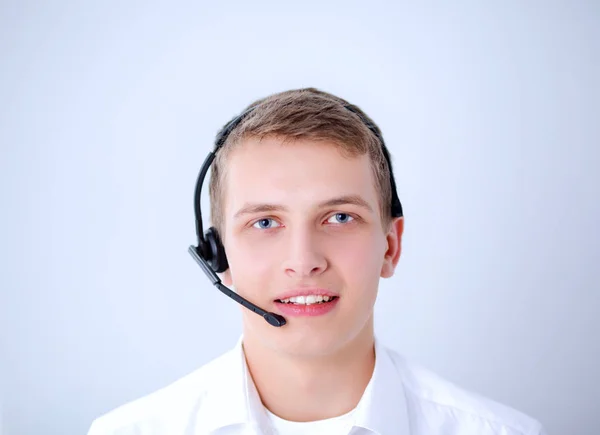 Portret van de jonge man die lacht zittend op een grijze achtergrond. Portret van jonge man — Stockfoto