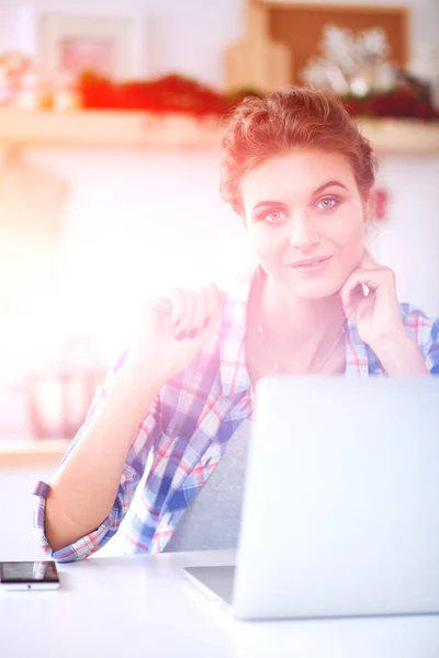 Lachende vrouw online winkelen met behulp van computer- en credit card in keuken. Lachende vrouw — Stockfoto