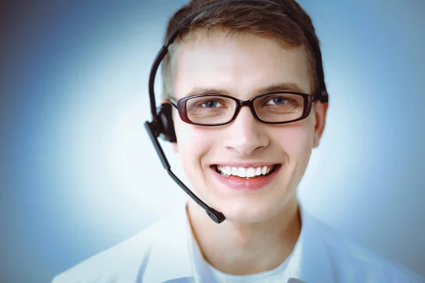 Portrait of young man smiling sitting on gray background. Portrait of young man — Stock Photo, Image