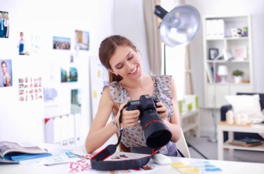 Çatı katı dairesinde oturan kamera ile gülümseyen genç kadın portresi