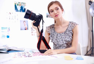 Çatı katı dairesinde oturan kamera ile gülümseyen genç kadın portresi