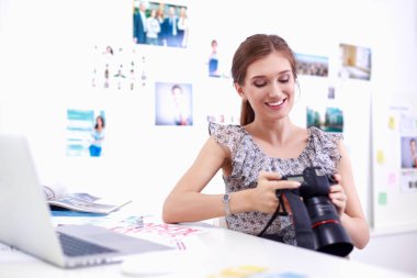 Çatı katı dairesinde oturan kamera ile gülümseyen genç kadın portresi