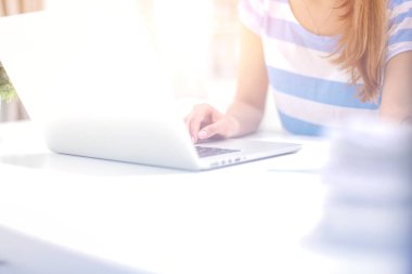 Elinde evrakları olan kadın masanın üstünde oturuyor.