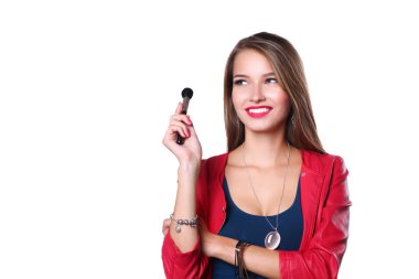 Genç güzel kadın elinde makyaj için fırça tutar .