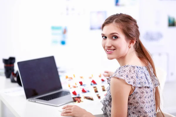 Portret van lachende jonge vrouw met camera zitten in loft appartement — Stockfoto