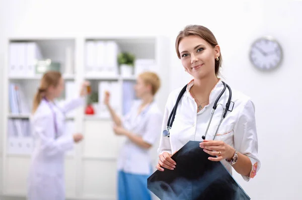 Young woman doctor standing at hospital with medical stethoscope — Stock Photo, Image