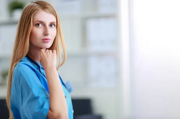 Retrato de médico mulher com pasta no corredor do hospital — Fotografia de Stock