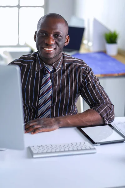 Schöner afroamerikanischer Geschäftsmann im klassischen Anzug benutzt einen Laptop und lächelt bei der Arbeit im Büro — Stockfoto