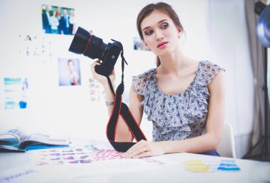 Çatı katı dairesinde oturan kamera ile gülümseyen genç kadın portresi