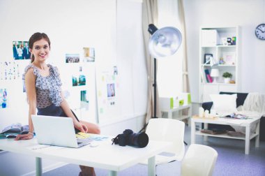 Çatı katı dairesinde oturan kamera ile gülümseyen genç kadın portresi