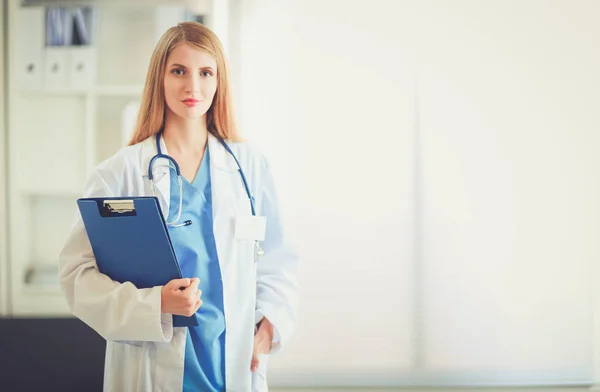 Retrato de médico mulher com pasta no corredor do hospital — Fotografia de Stock