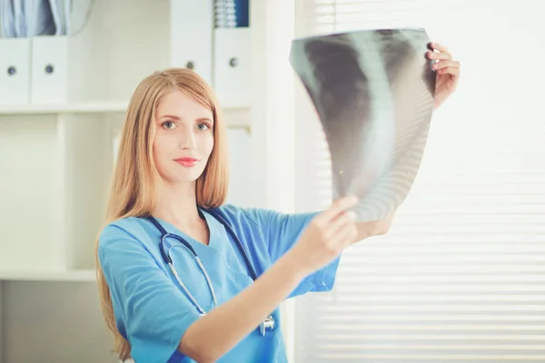 Doctora joven mirando la imagen de rayos X — Foto de Stock