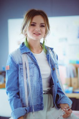 Moda tasarımcısı kadın stüdyoda tasarımları üzerinde çalışıyor.