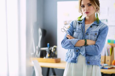 Moda tasarımcısı kadın stüdyoda tasarımları üzerinde çalışıyor.