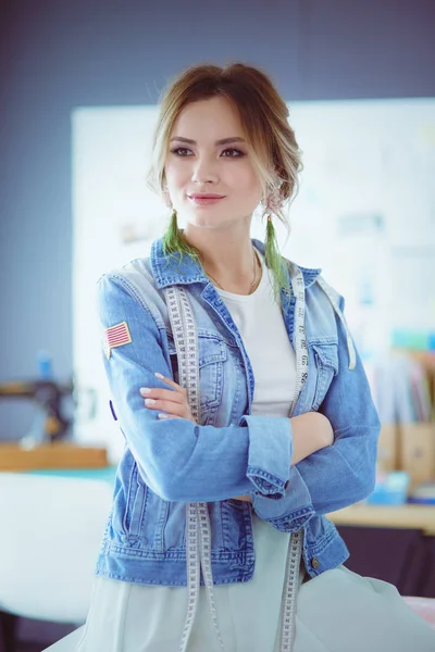 Moda tasarımcısı kadın stüdyoda tasarımları üzerinde çalışıyor.