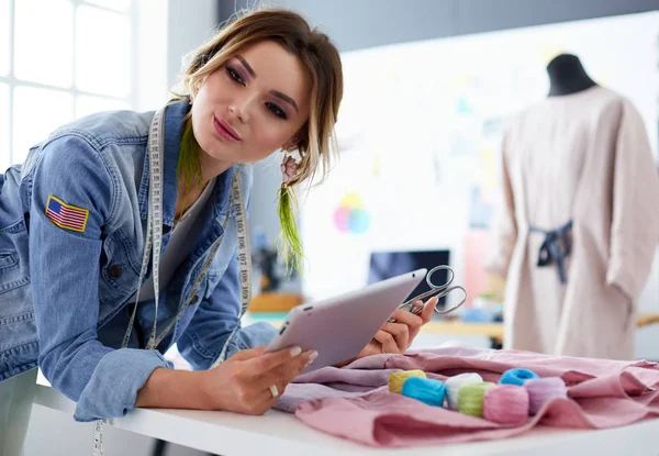 Moda tasarımcısı kadın stüdyoda tasarımları üzerinde çalışıyor.