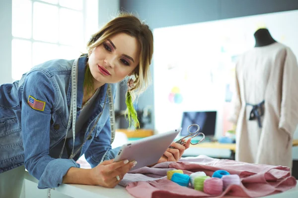 Moda tasarımcısı kadın stüdyoda tasarımları üzerinde çalışıyor.
