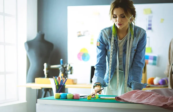 Mulher designer de moda trabalhando em seus projetos no estúdio — Fotografia de Stock