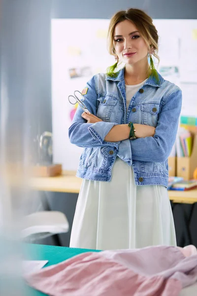 Moda tasarımcısı kadın stüdyoda tasarımları üzerinde çalışıyor.