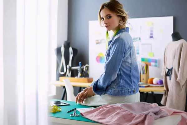 Moda tasarımcısı kadın stüdyoda tasarımları üzerinde çalışıyor.