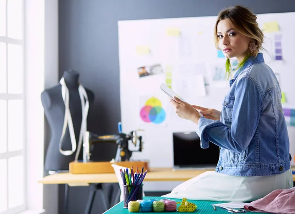 Moda tasarımcısı kadın stüdyoda tasarımları üzerinde çalışıyor.