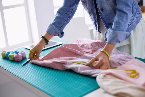 Moda tasarımcısı kadın stüdyoda tasarımları üzerinde çalışıyor.