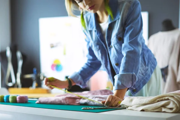 Mulher designer de moda trabalhando em seus projetos no estúdio — Fotografia de Stock