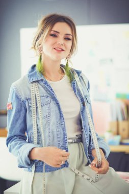 Moda tasarımcısı kadın stüdyoda tasarımları üzerinde çalışıyor.