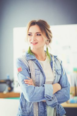 Moda tasarımcısı kadın stüdyoda tasarımları üzerinde çalışıyor.