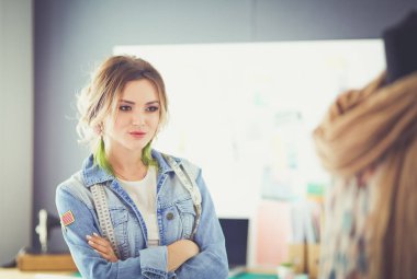 Moda tasarımcısı kadın stüdyoda tasarımları üzerinde çalışıyor.