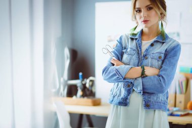Moda tasarımcısı kadın stüdyoda tasarımları üzerinde çalışıyor.